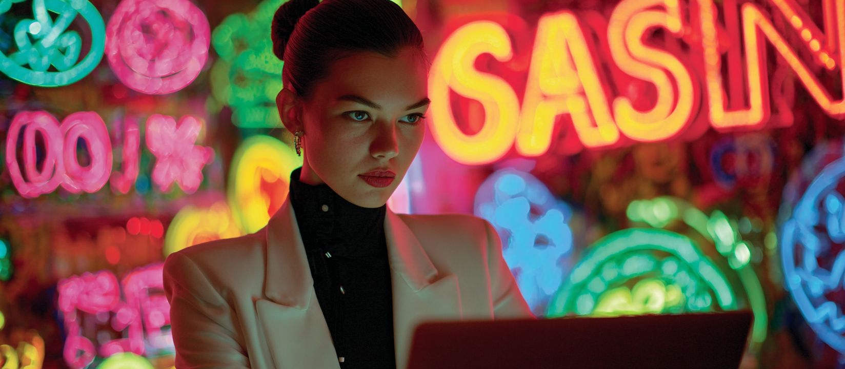 Discover exciting online casino games at DB222 Stylish woman in white jacket playing online casino games on laptop with colorful neon casino lights in the background
